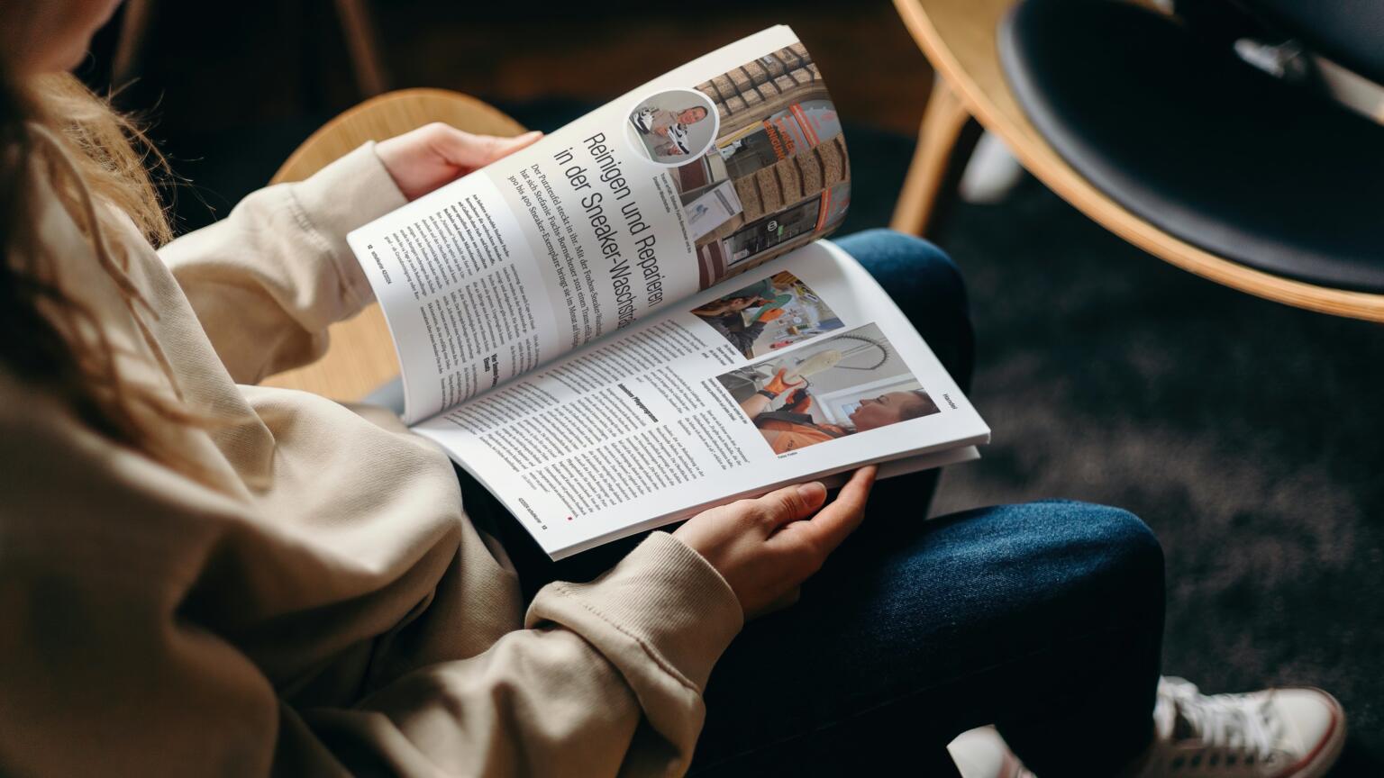 Mädchen mit Sneakers, blättert in der Zeitschrift Schuhkurier.